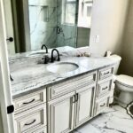 A bathroom with a marble countertop and toilet.