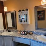 A newly remodeled bathroom with dual sinks and mirrors.