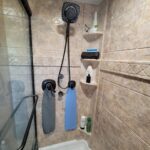A tiled shower with a towel rack in the bathroom.