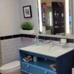 A blue sink and mirror in the bathroom.