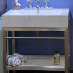 A bathroom vanity with a mirror and towels is perfect for a bathroom remodel.