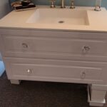A white bathroom vanity with two drawers and a mirror is a essential component of any bathroom remodel.