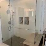 A bathroom with a sleek glass shower enclosure.
