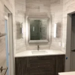 A bathroom with a wooden vanity and mirror, ideal for a bathroom remodel.