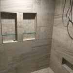 A tiled shower with a glass shower door is a luxurious addition to any bathroom remodel.