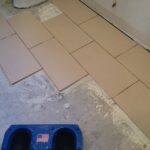 Tiling is being installed in a bathroom as part of a remodel.