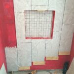 The bathroom remodel includes tiling and vibrant red walls.