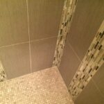 A shower with tiled walls and a floor.