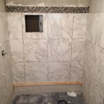 A bathroom is being remodeled with luxurious marble tiles.