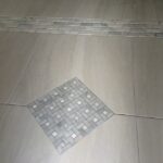 A bathroom with a tiled floor for shower.