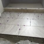 A tile floor is being installed during a bathroom remodel.