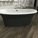 A bathtub placed on a wooden floor in a store.
