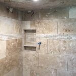 A tiled shower with beige tiles and a tiled floor is perfect for a bathroom remodel.