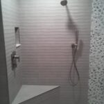 A tiled shower with a shower head.