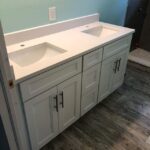 A white bathroom vanity with dual sinks.