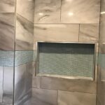 A shower with a glass door and tiled walls is essential in any bathroom remodel.