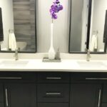 A bathroom remodel with black cabinets and a purple flower.