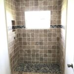 A bathroom with tile floors and a window, perfect for a bathroom remodel.