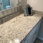 A bathroom with granite counter tops and a mirror for a bathroom remodel.