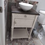 A bathroom with a white sink and tiled floor, perfect for a bathroom remodel.