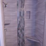 A modern shower with glass door and tiled walls, perfect for a bathroom remodel.