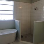 A small bathroom with a bathtub and shower, perfect for a bathroom remodel.