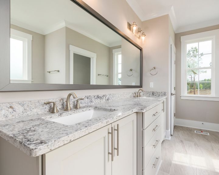 A bathroom with granite counter tops and a large mirror.