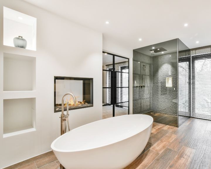 A modern bathroom with a bathtub and fireplace.