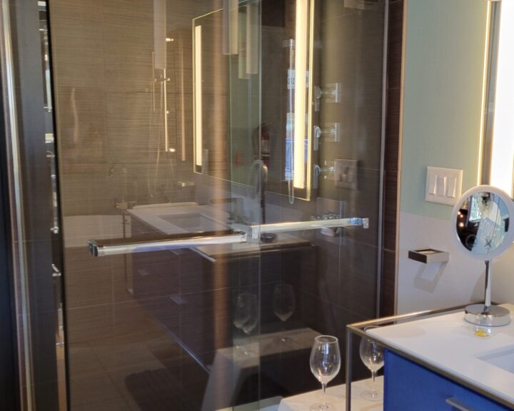 A bathroom with a glass shower door and tiling.