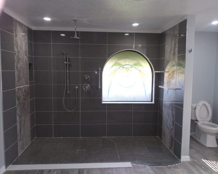 A bathroom with an arched window and tiled floor, perfect for a bathroom remodel.