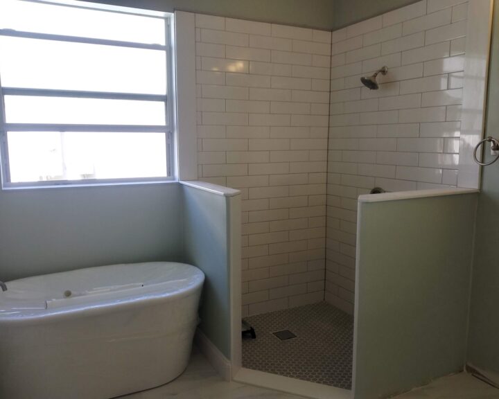 A small bathroom with a bathtub and shower, perfect for a bathroom remodel.