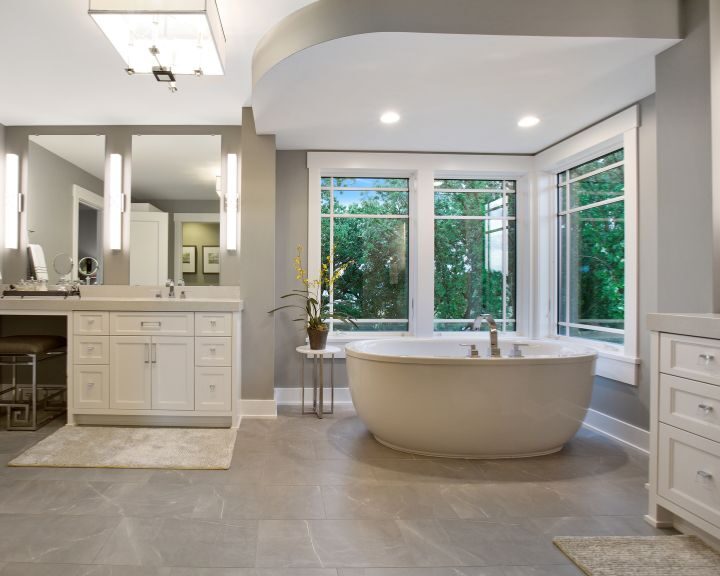 A large bathroom with a large tub and sink, featuring modern tiling.