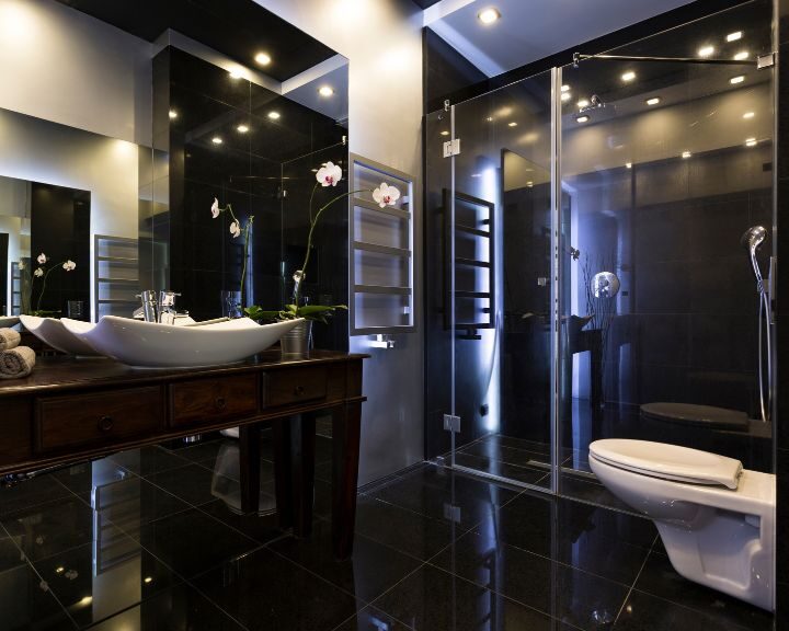 A black bathroom with a toilet.