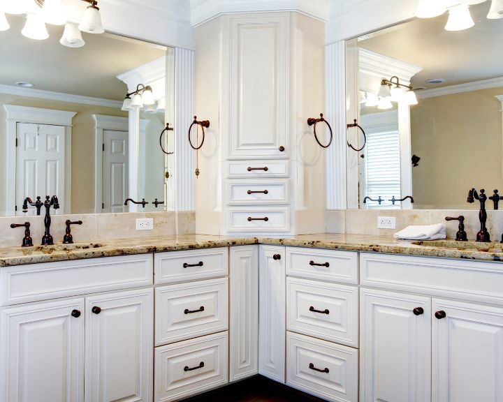 A bathroom with white cabinets and granite countertops.