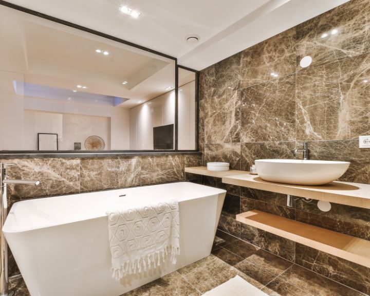 A bathroom with marble walls and a bathtub for a luxurious bathing experience.