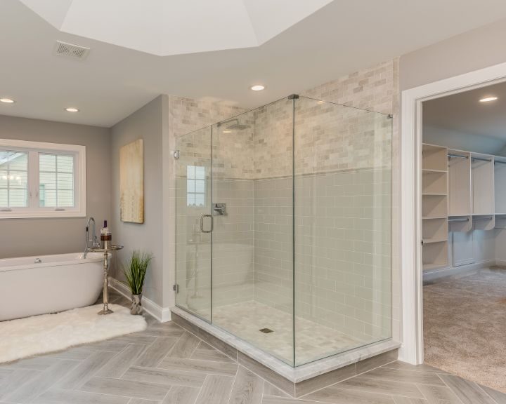 A spacious bathroom with a glass shower stall.