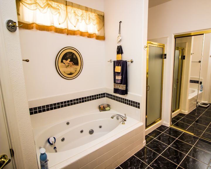 A luxurious black and gold bathroom featuring a jacuzzi tub.