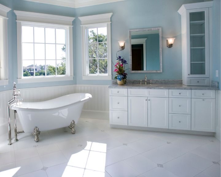 A white bathroom with blue walls and a bathtub for a relaxing soak after a long day.