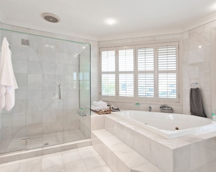 A white bathroom featuring a spacious bathtub and shower.