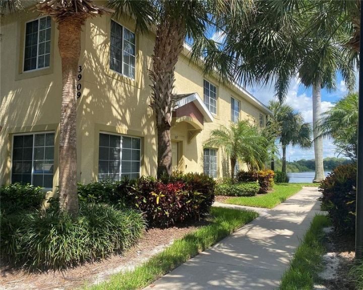 An apartment complex with lush palm trees and bushes.