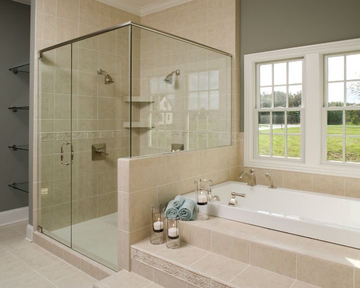A bathroom with a sleek glass shower stall and tub.