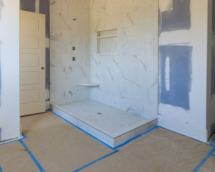 A bathroom with blue tape being remodeled.