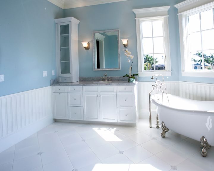 A white bathroom with blue walls and a bathtub.
